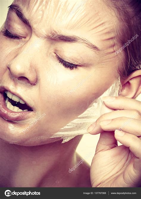 Woman Removing Facial Peel Off Mask Stock Photo By ©voyagerix 137767068