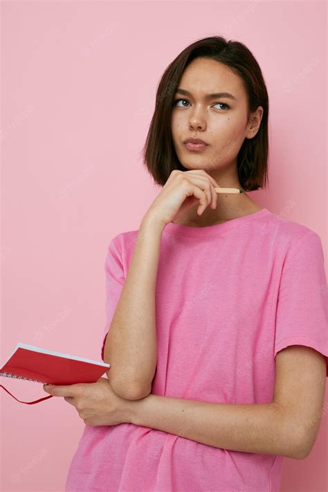 premium photo short haired brunette emotions posing with notepad learning pink background