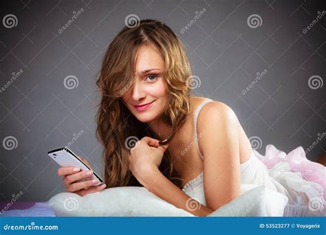 Mulher Na Cama Que Guarda O Telefone Celular Imagem De Stock Imagem De Tecnologia Humano