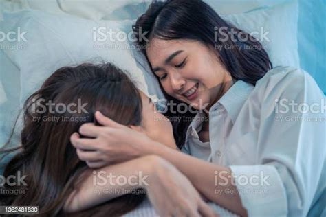 asian beautiful lesbian couple lying down on bed and hugging each other attractive romantic girl