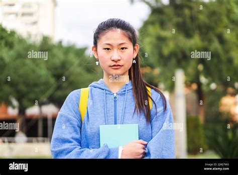 Portrait Of Serious Teenager Student Standing At University Campus