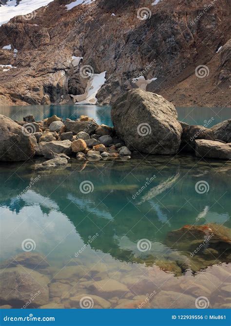 Large Stones Lying In A Turquoise Mountain Lake Mountain Reflecting In