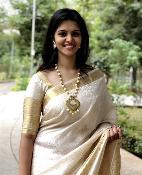 In A Kerala Style White And Gold Color Saree And Elbow Length Sleeve