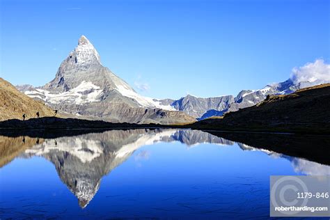 Hikers Admiring The Matterhorn Reflected Stock Photo