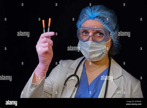 Woman Doctor Holds Syringes In His Hand On A Black Background Concept