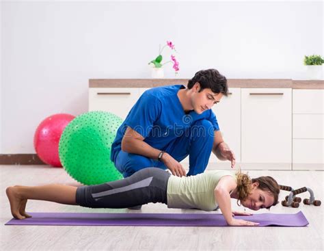 Fitness Instructor Helping Sportsman During Exercise Stock Photo