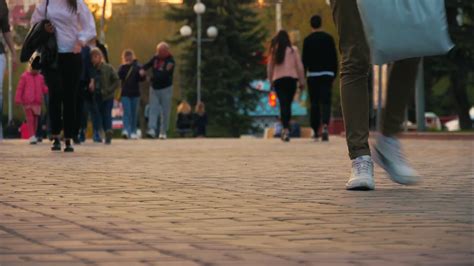Timelapse crowds of people walking on city pavement tiles. The footsteps of a crowd of people go ...