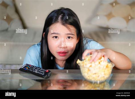 Young Beautiful And Relaxed Asian Chinese Woman Watching Korean Drama On Television On Sad