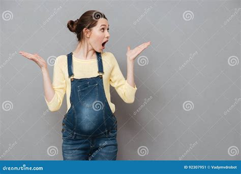 surprised pregnant woman pointing finger up isolated over yellow background lady with widely