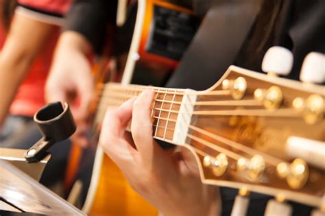 Man With His Fingers On The Frets Of Guitar Stock Photo Download