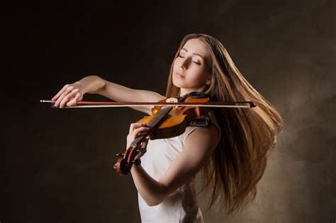 Premium Photo Beautiful Young Woman Playing Violin Over Black Background