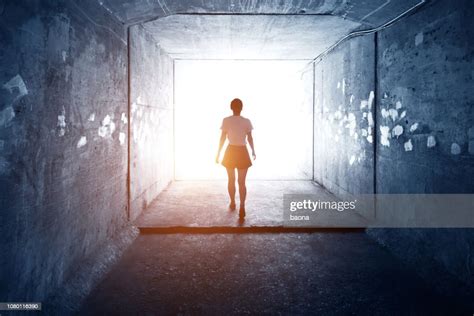Woman Walking Through A Dark Tunnel High Res Stock Photo Getty Images