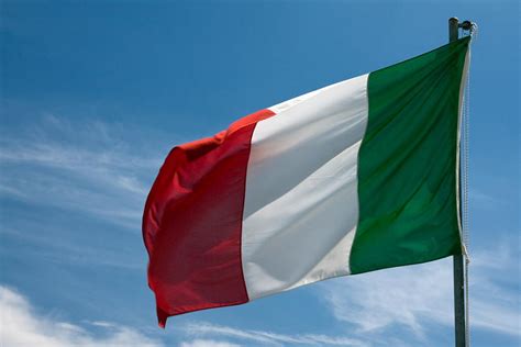 The flag of italy with a shield divided into four squares representing the four maritime republics: Italian Flag Flying Photograph by Sally Weigand