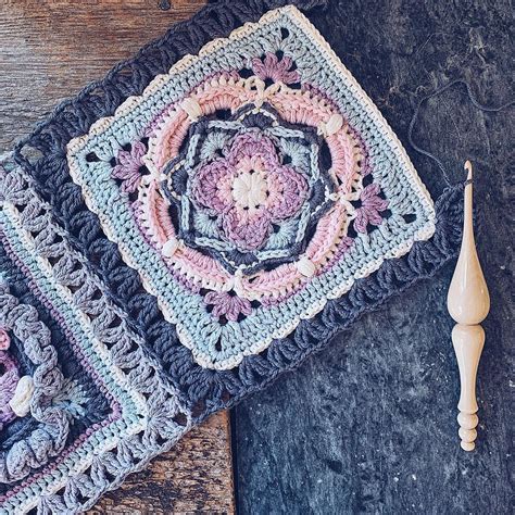 Two Crocheted Squares Are Sitting On A Table