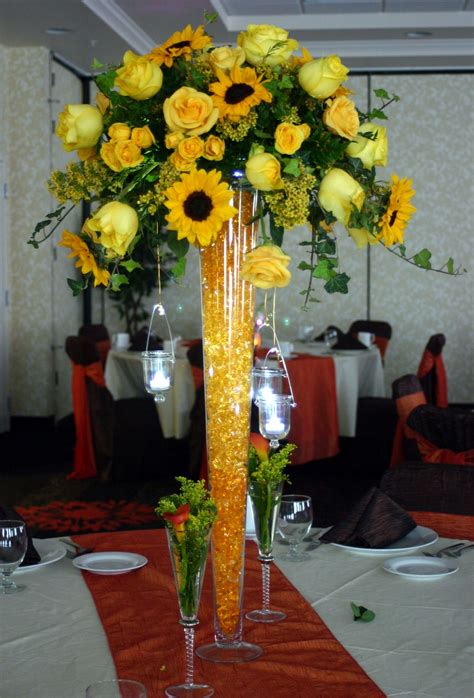 A Monochromatic Centerpiece Features Sunflowers Roses And Hanging