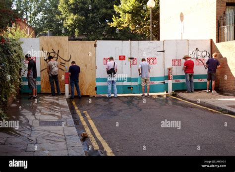 Men Urinating Against Hoardings In West London At Notting Hill Stock