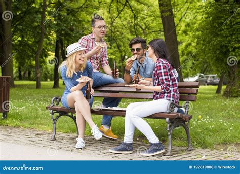 Cheerful Group Of Caucasian Friends Drinking Beer And Eating Pizza On A