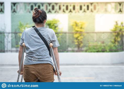 Disabled Woman With Crutches Or Walking Stick Or Knee Support Standing