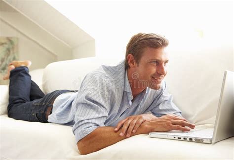 Man Using Laptop Relaxing Sitting On Sofa At Home Stock Photo Image
