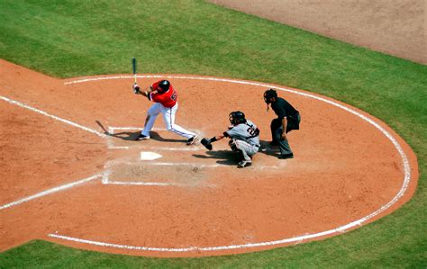 Baseball Player Standing on Baseball Stadium With Two Men · Free Stock