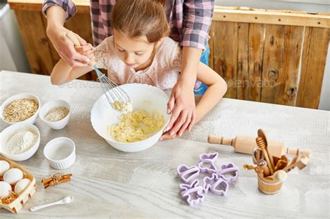 Mother Teaching Daughter Prepare Dough Together In Kitchen Stock