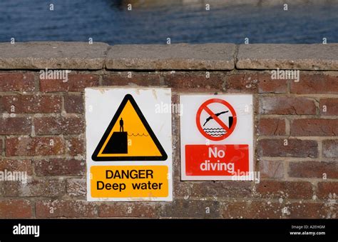 Signs Saying Danger Deep Water And No Diving On A Wall At The Side Of