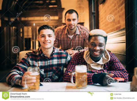 Multiracial Friends Group Drinking And Toasting Beer At Pub Friendship