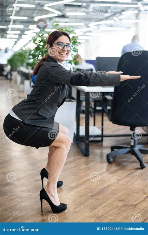 Happy Business Woman Squat In Open Space Office A Red Haired Smiling Female Employee In A Skirt