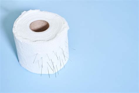 Roll Of Toilet Paper With Nails On Blue Background Hemorrhoid