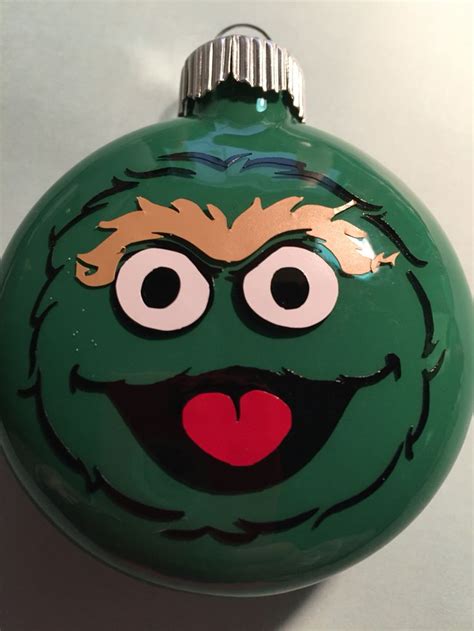 A Green Ornament With A Face Painted On It