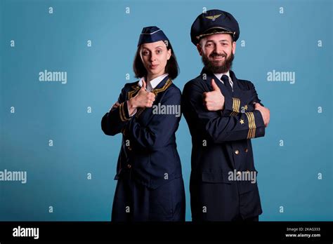 Smiling Airplane Pilot And Flight Attendant Showing Thumbs Up Gesture Portrait Airplane Crew In
