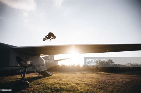 Athletic Man Jumping While Doing Pushups On A Airplane Wing High Res