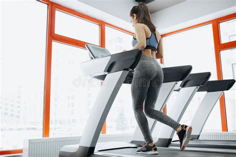 Young Fit Pretty Woman Doing Exercises On The Treadmill Stock Photo