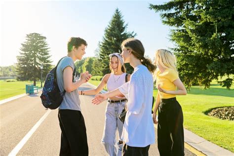 Meeting Of Smiling Teenage Friends In A Sunny Summer Park Stock Photo