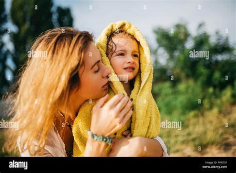 Mother Covering Daughter With Towel After Swimming In Water Stock Photo