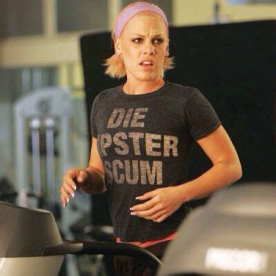 A Woman With Pink Hair Standing In Front Of An Exercise Machine And