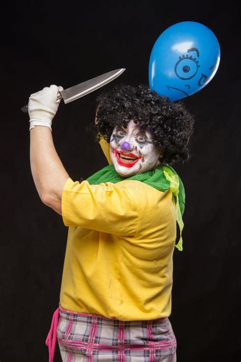 Angry Ugly Clown Wants To Kill A Balloon In The Cap Stock Photo Image