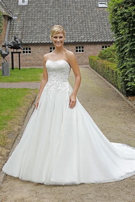 Der schmeichelnde wickelausschnitt besteht aus zwei bändern, welche am vorderteil überkreuzt und mit einem knotenband charmant gerafft werden. Dieses wunderhübsche Brautkleid ist von Amelie Bridal und ...