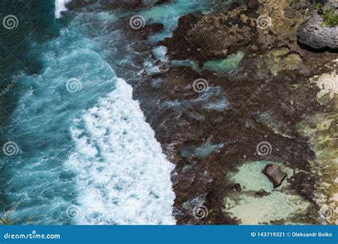Aerial View Of Blue Ocean Waves Crashing Into Rocky Coast Stock Image