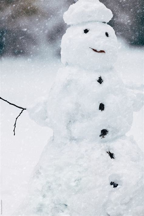 Cute Snowman Smiling In Snowfall On Winter Nature By Stocksy