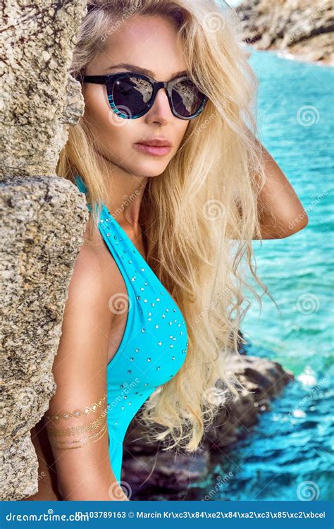 Beautiful Smiling Blonde Model Wearing A Bikini In A Pool Side Photo