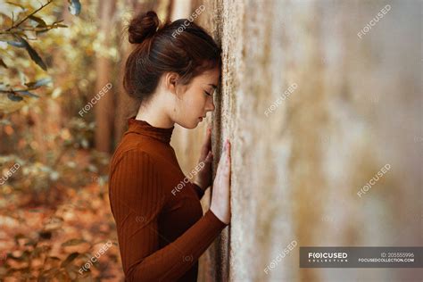 Woman Leaning Forehead Against Wall — Casual Female Stock Photo