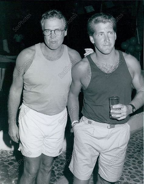 Two Men Standing Next To Each Other In Shorts