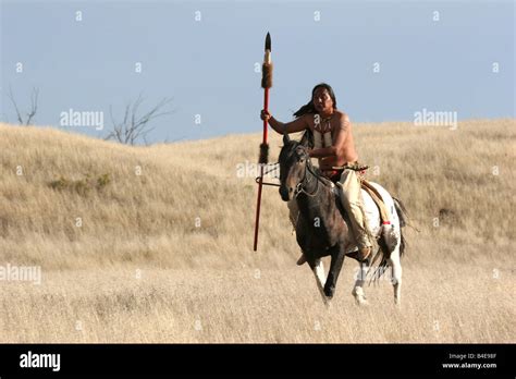 A Native American Lakota Indian Riding Horseback In The Prairie Of