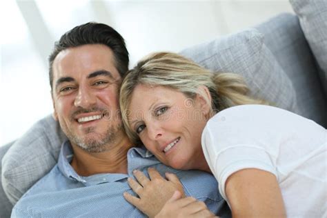 Smiling Mature Couple Relaxing On Sofa Stock Image Image Of Embracing