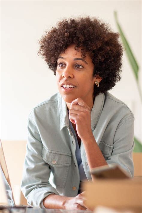 Attractive Black Woman Sitting At Table In Home Office Stock Image