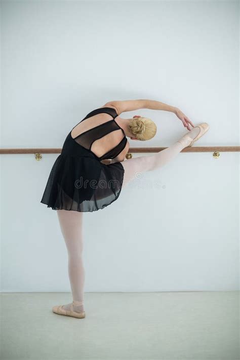 Ballerina Stretching On A Barre While Practicing Ballet Dance Stock