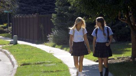 Two Teenage Girls Talking And Walking In School Uniforms Stock Video