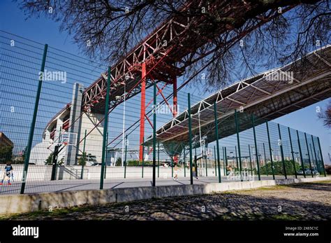 Sunny day at basketball courts enclosed by green metal fencing, with