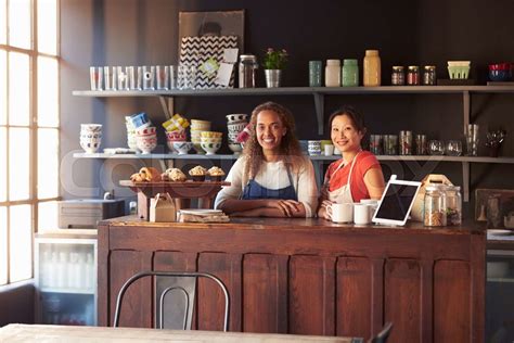 Two Female Coffee Shop Owners Standing Behind Counter Stock Image